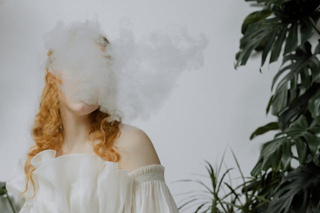 a woman blowing a dense vape cloud