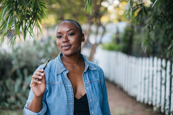 a woman holding a vape pen for longest lasting disposable vape