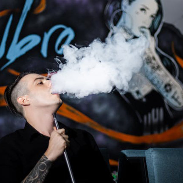 a person blowing a large vape cloud for how to vape